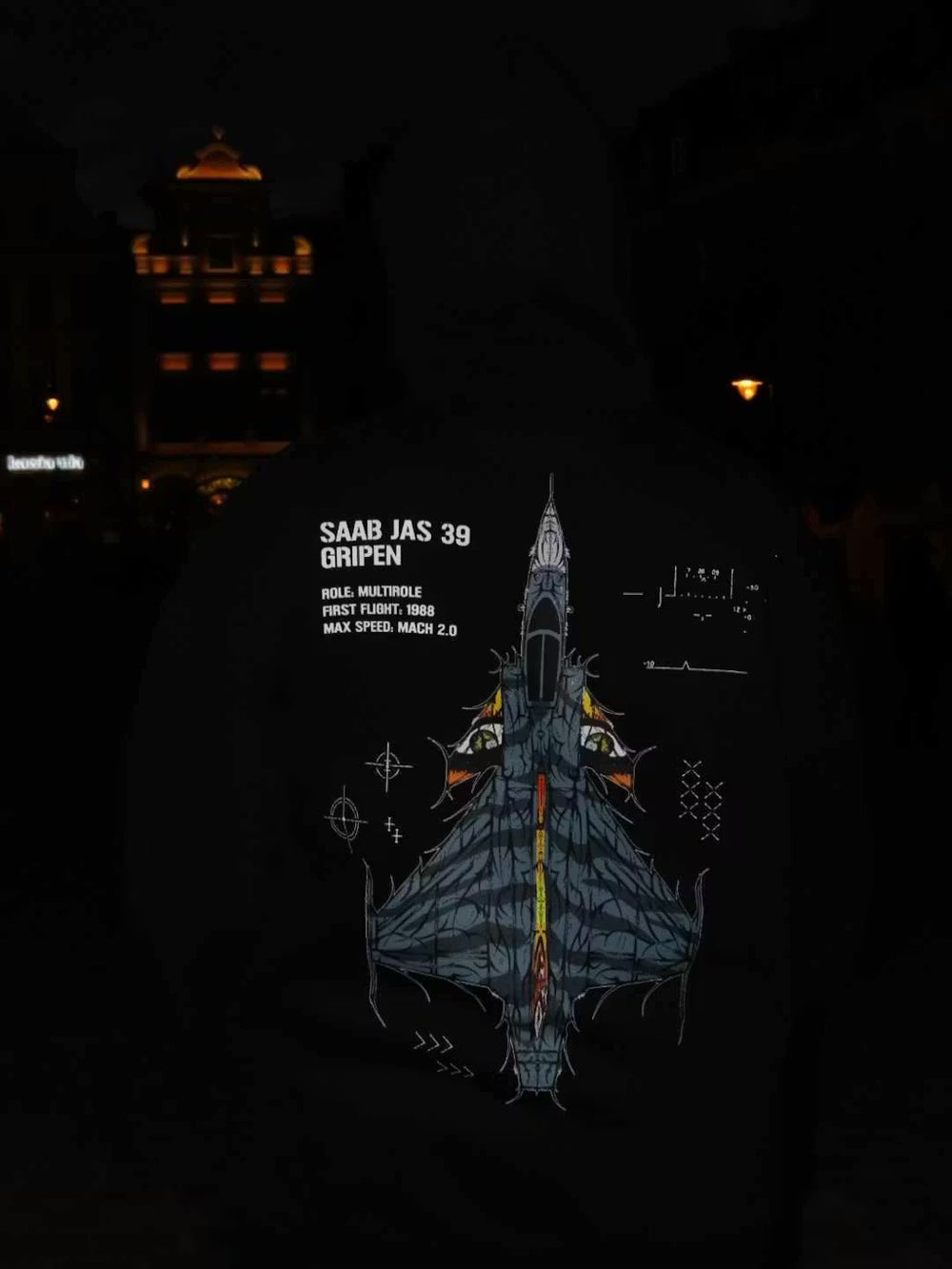 Black hoodie with aviation-inspired Saab JAS 39 Gripen jet graphic and technical specs at night