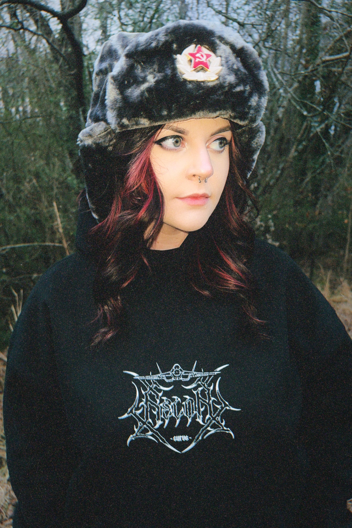 Woman in aviation-inspired streetwear hoodie and faux fur ushanka hat outdoors