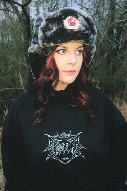 Woman in aviation-inspired streetwear hoodie and faux fur ushanka hat outdoors