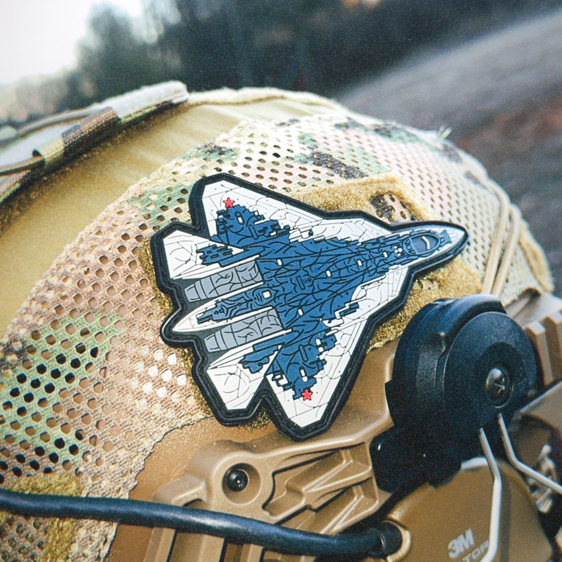 Aviation-inspired fighter jet patch on tactical mesh helmet outdoors