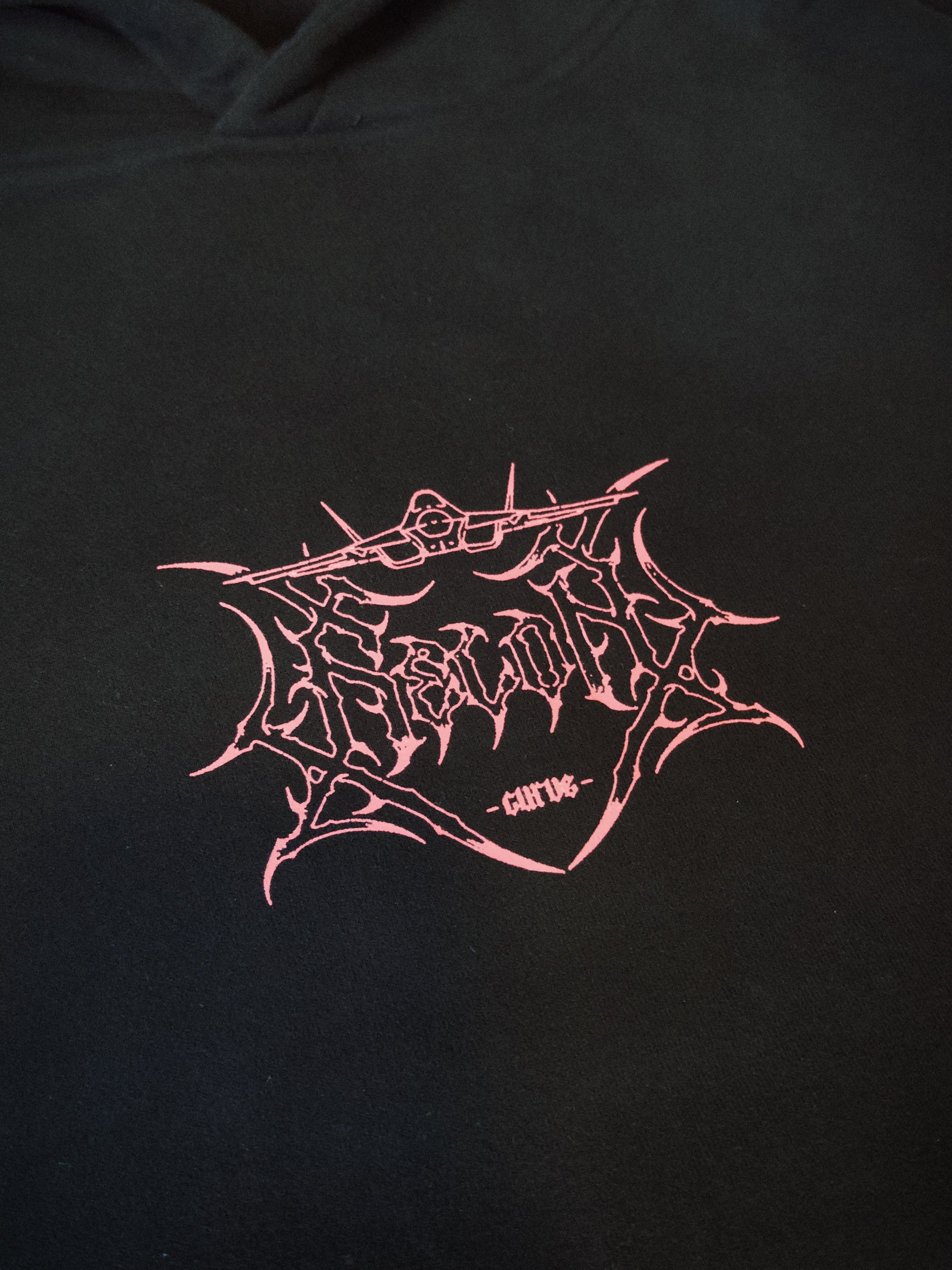 Black hoodie with pink aviation-inspired graphic logo and sharp linework on chest