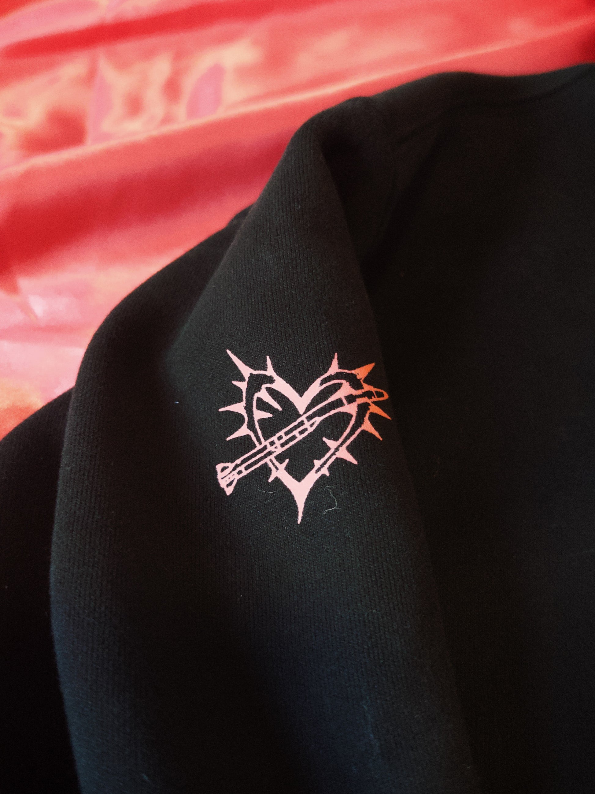 Black streetwear tee with pink heart and barbed wire graphic, bold modern tactical style