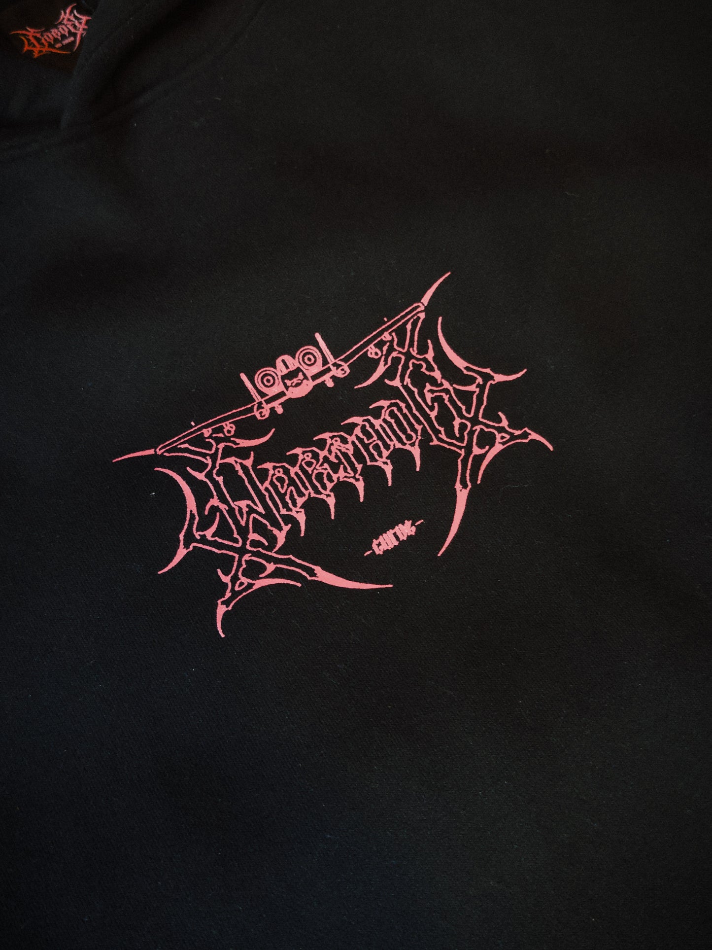 Black streetwear hoodie with pink aviation-inspired chest graphic and sharp linework design