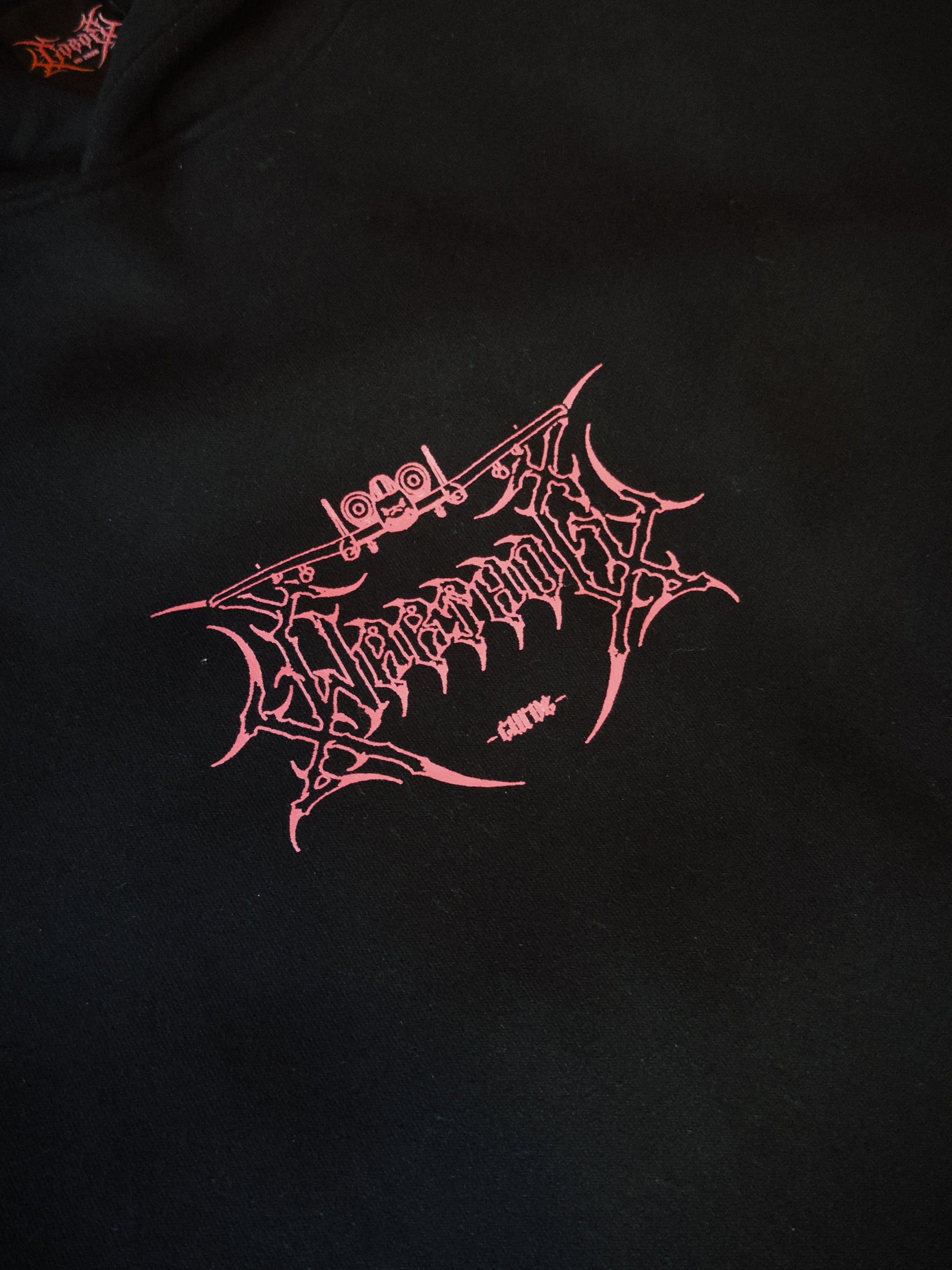 Black streetwear hoodie with pink aviation-inspired chest graphic and sharp linework design