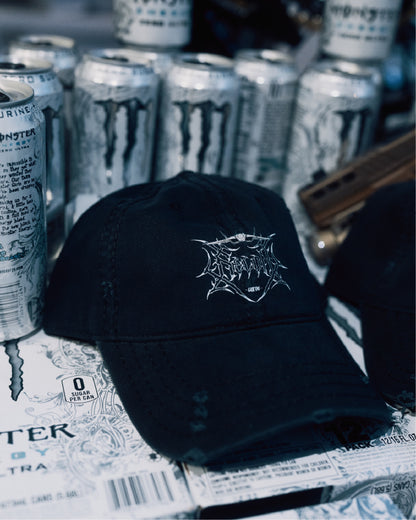Black baseball cap with graphic logo, placed on energy drink boxes and cans background